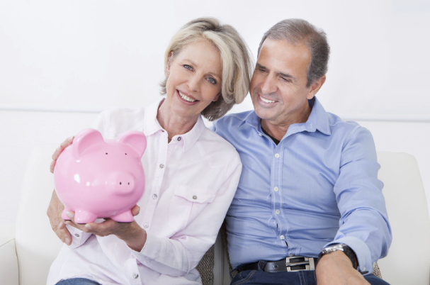 Older couple holding a piggy bank